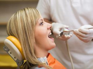 Dentist is doing treatment procedures in dental office.
